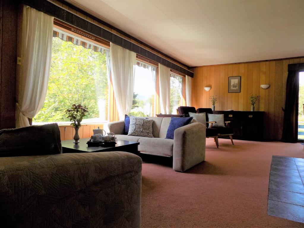 uma sala de estar com sofás e uma grande janela em Kråkehaugen Feriehus, a perfect holiday retreat near Åheim em Åheim