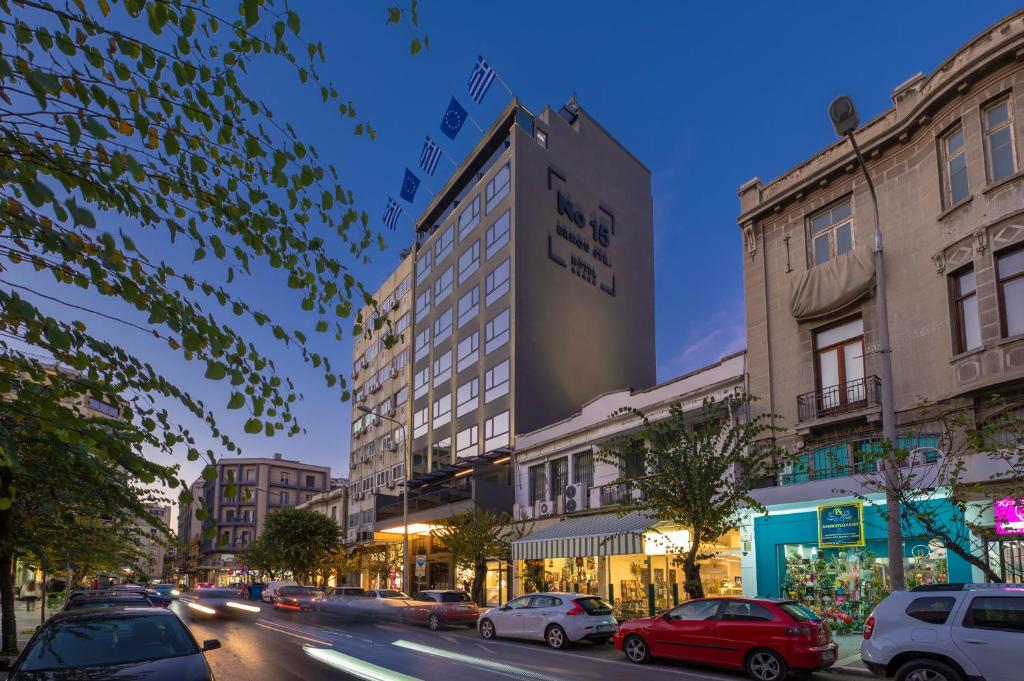 una strada di città con auto parcheggiate di fronte agli edifici di No 15 Ermou Hotel a Salonicco