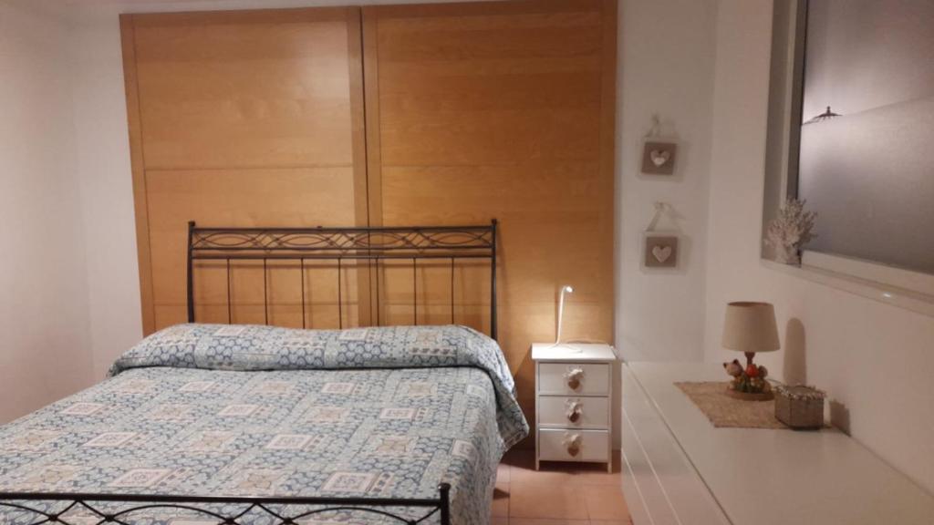 - une chambre avec un lit, une tête de lit en bois et une table de chevet dans l'établissement Da Esterina appartamento sulla riviera del Brenta, à Mira