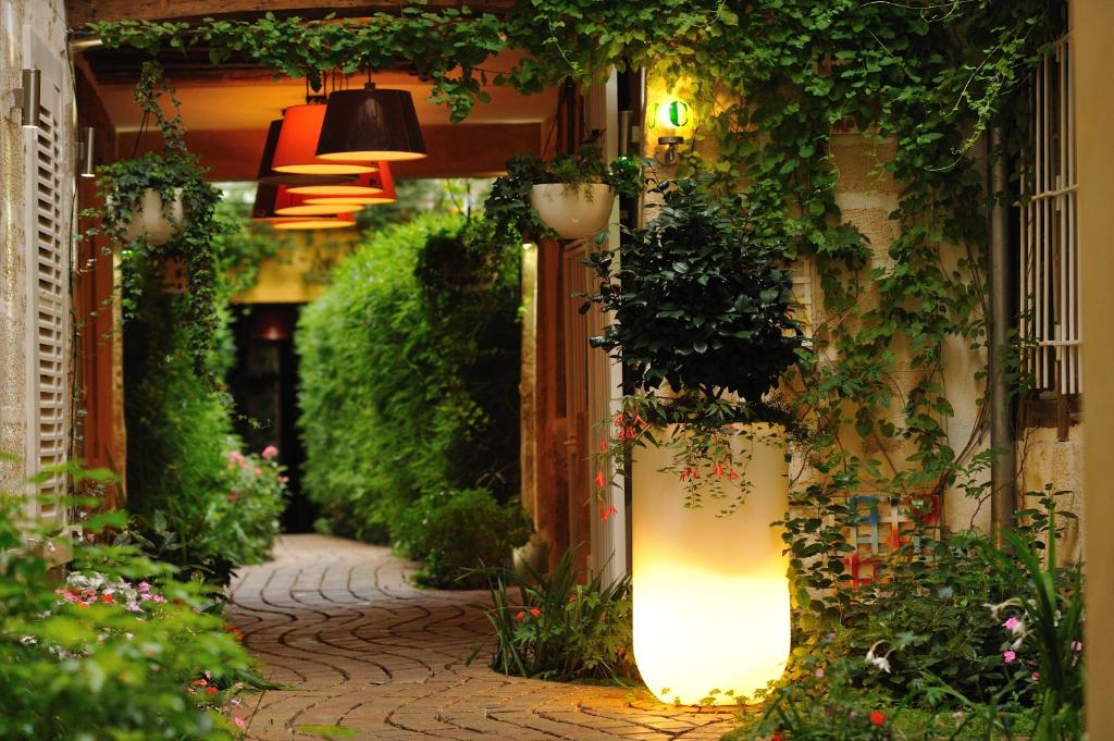 a cobblestone alley with plants and flowers on a building at Les Patios du Marais 1 in Paris