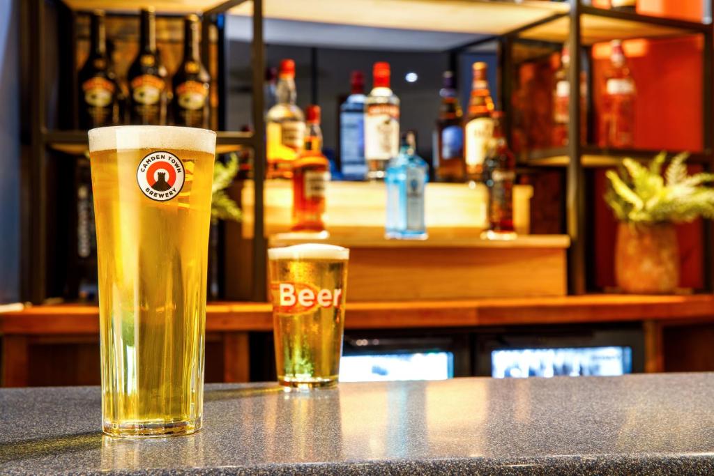 a glass of beer sitting on top of a counter at ibis Styles Birmingham Centre in Birmingham