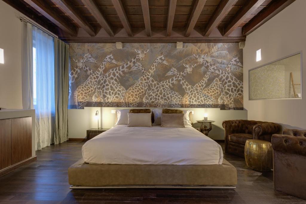 ein Schlafzimmer mit einem großen Bett und einem Sofa in der Unterkunft PALAZZO DUOMO Suites in Udine Center in Udine