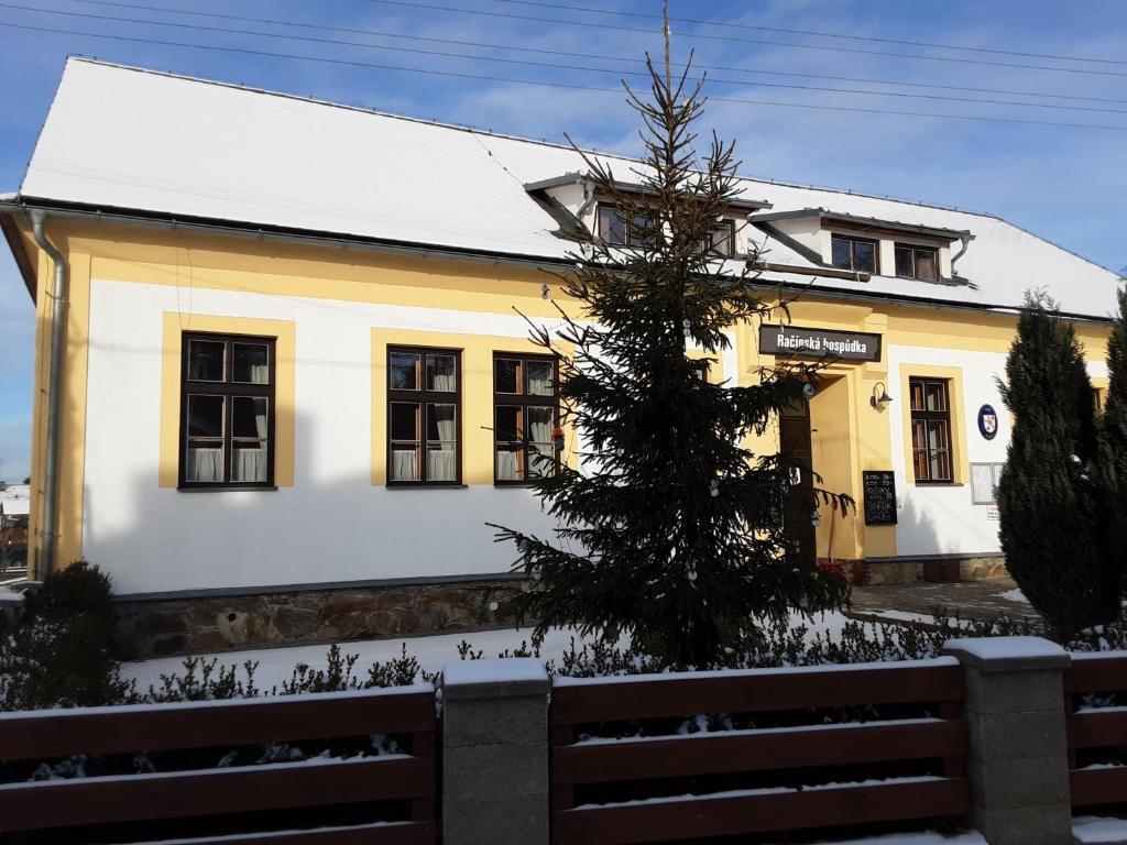 un edificio blanco con un árbol delante en Račínská hospůdka, en Velká Losenice
