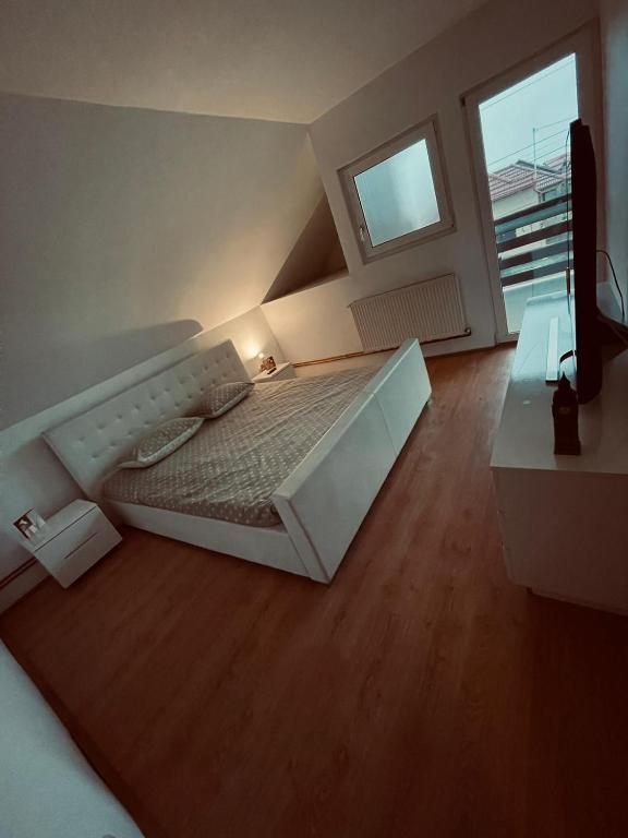 ein großes Bett in einem Zimmer mit einem großen Fenster in der Unterkunft Casa Verde in Foeni