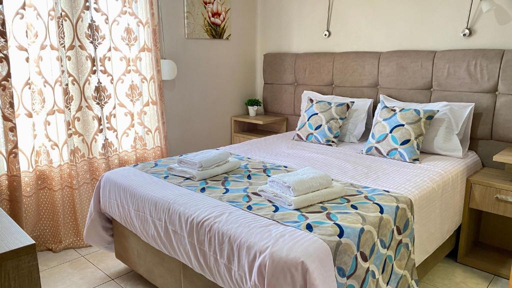 ein Schlafzimmer mit einem Bett mit Handtüchern darauf in der Unterkunft Pelineon Rooms in Chios