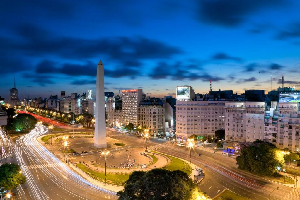 une ville de nuit avec un grand obélisque au milieu dans l'établissement Globales Republica, à Buenos Aires