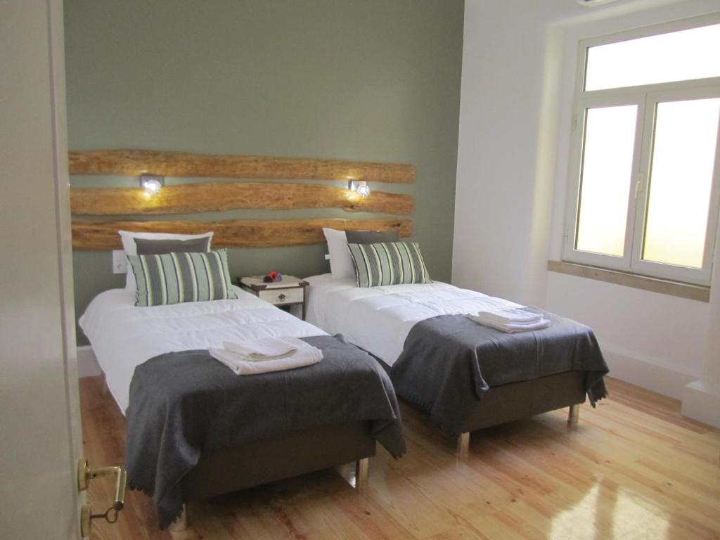 una camera da letto con due letti e una finestra di GoodTime Marquês Suites a Lisbona