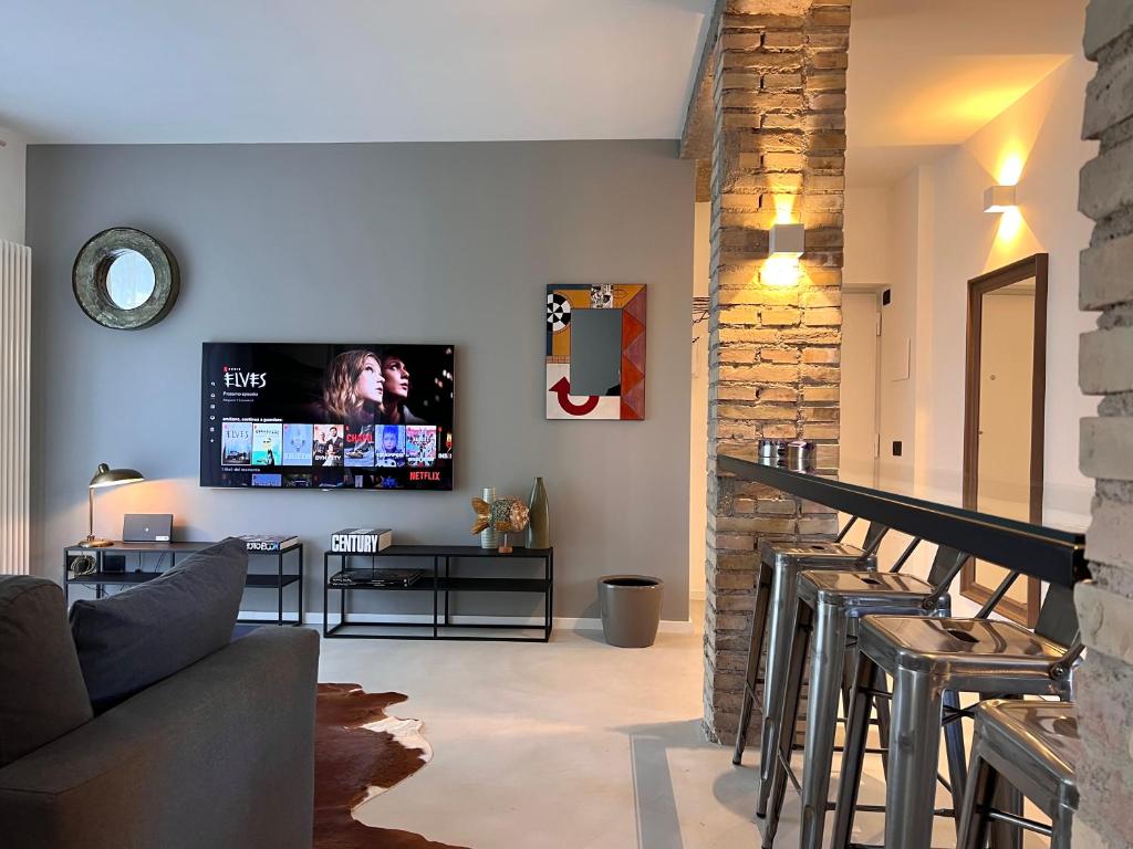 罗马RomeAsYouLike - Magenta Loft的客厅里有一张沙发，墙上有一台电视