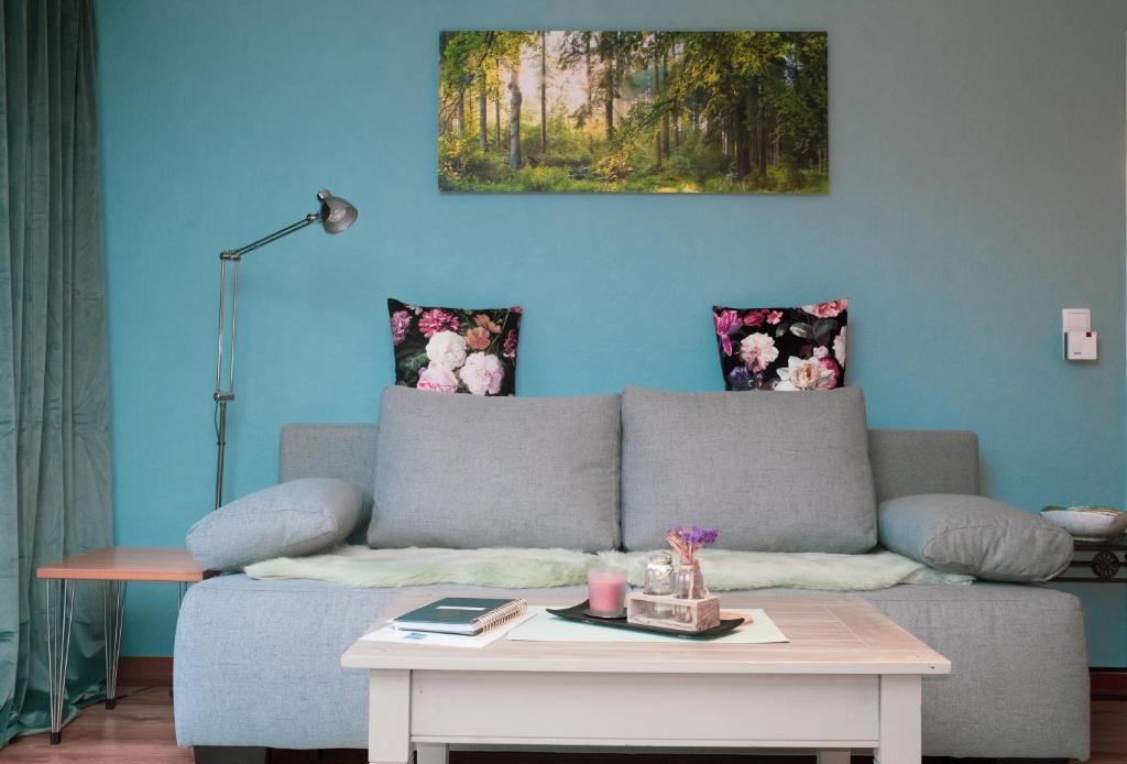 a blue living room with a couch and a table at Ferienwohnungen Glockenberg in Altenau