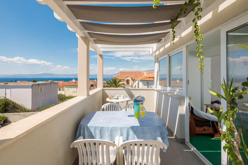 een patio met een tafel en stoelen op een balkon bij Apartment Oaza in Supetar