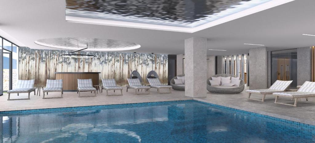 a living room with a pool and chairs and a fireplace at Ammoa Luxury Hotel & Spa Resort in Nikiti