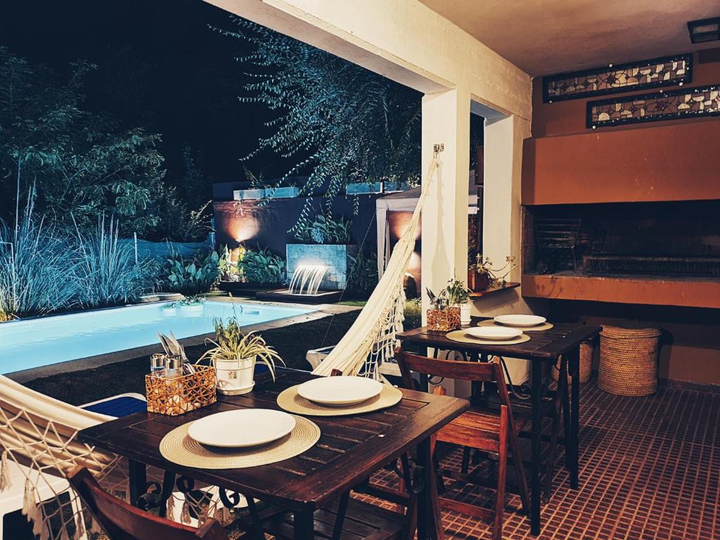 un patio con mesa, sillas y piscina en Posada Piedramora en Mina Clavero