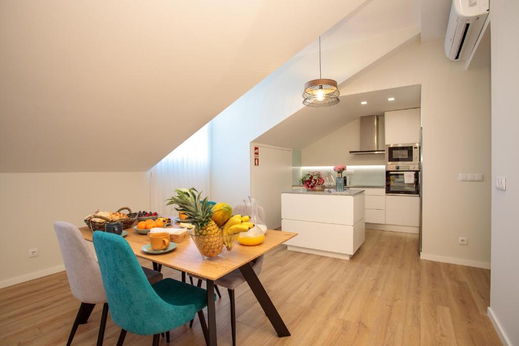 eine Küche und ein Esszimmer mit einem Tisch und Stühlen in der Unterkunft BESTVILLAS Collection Lilium in Braga