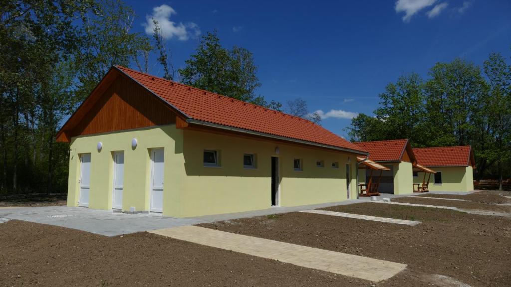 a building with a red roof on a parking lot at Familia Camping Balaton in Balatonőszöd