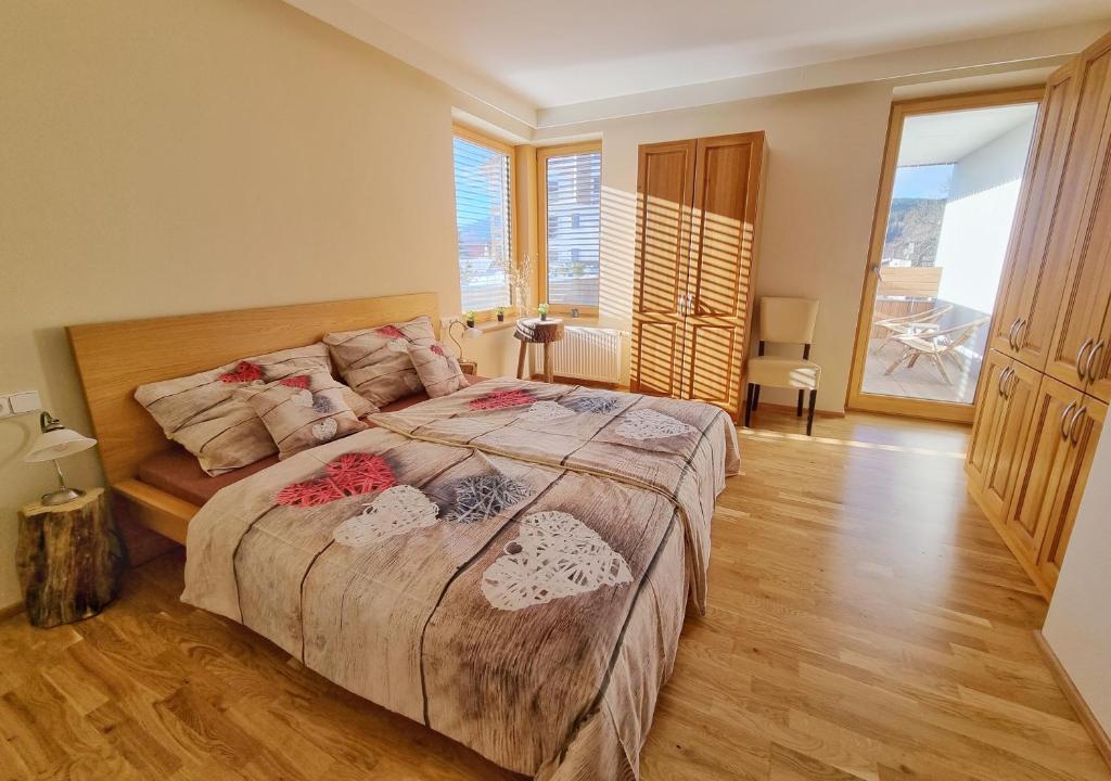 una camera con un grande letto e pavimenti in legno di Horský Apartmán Klostermann a Železná Ruda