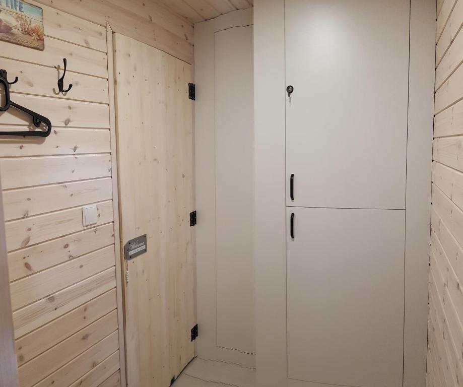 a room with a closet and a white refrigerator at Bungalow Mila Morska in Junoszyno