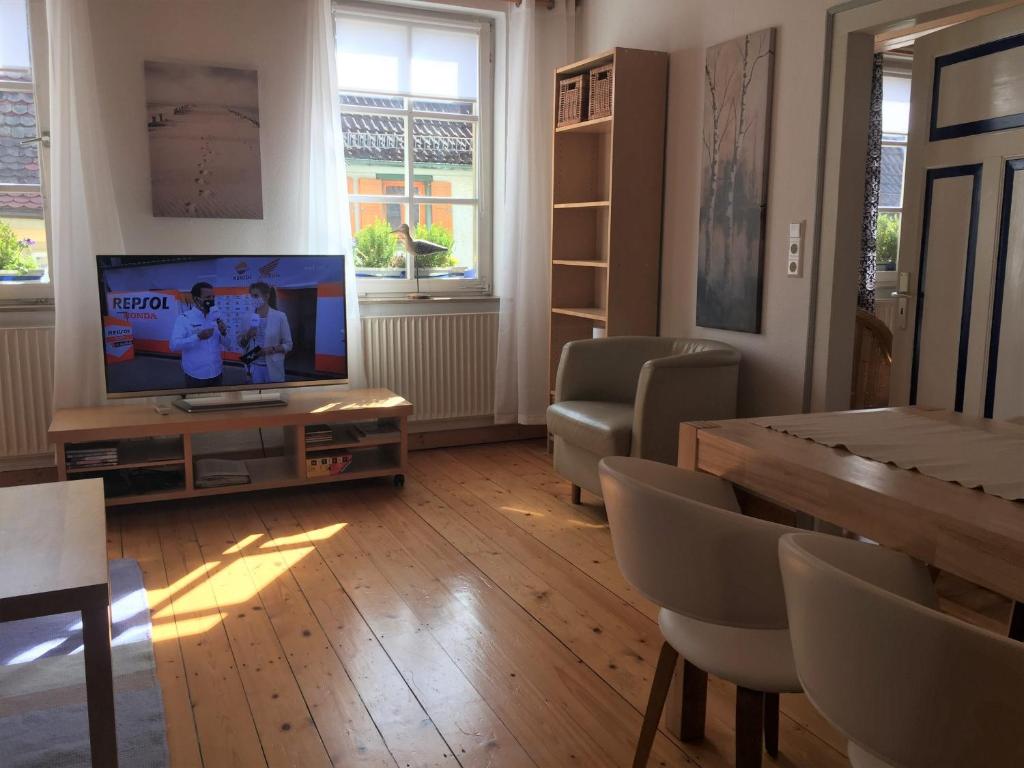 a living room with a television and a table and chairs at Ferienwohnungen Edition Bad Wimpfen in Bad Wimpfen