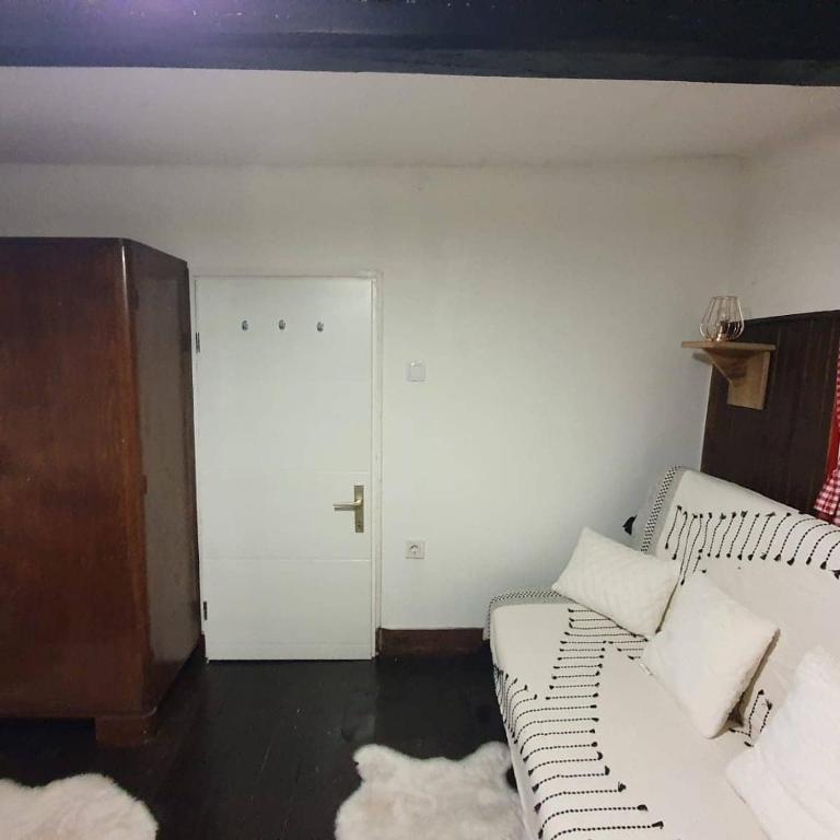 Vila Brajčić في Radatovići: غرفة معيشة بها أريكة بيضاء وباب أبيض