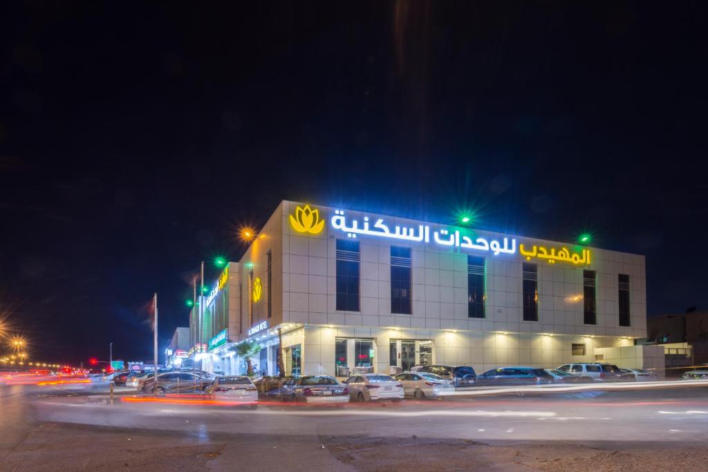 a building with a sign on it at night at Al Muhaidb Hotel Apartments 24 in Riyadh