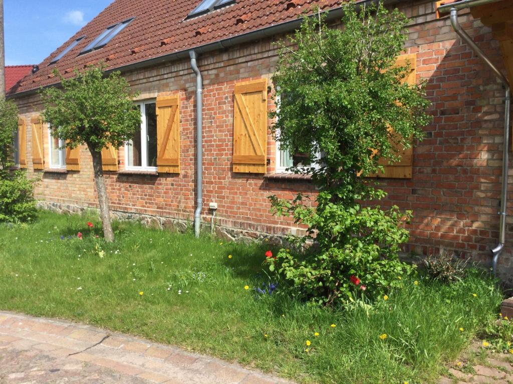 una casa de ladrillo con puertas amarillas y un árbol en Gülitzer Landhaus en Gülitz