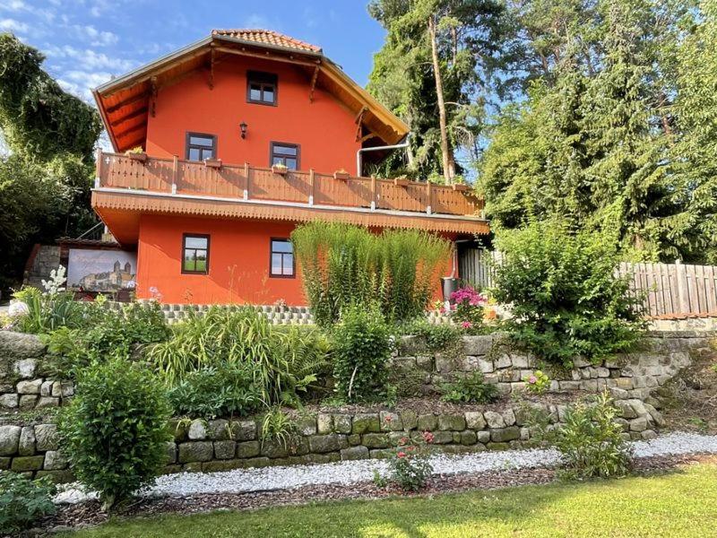 ein orangefarbenes Haus mit einem Zaun und einem Garten in der Unterkunft Ferienhaus Nicole in Quedlinburg