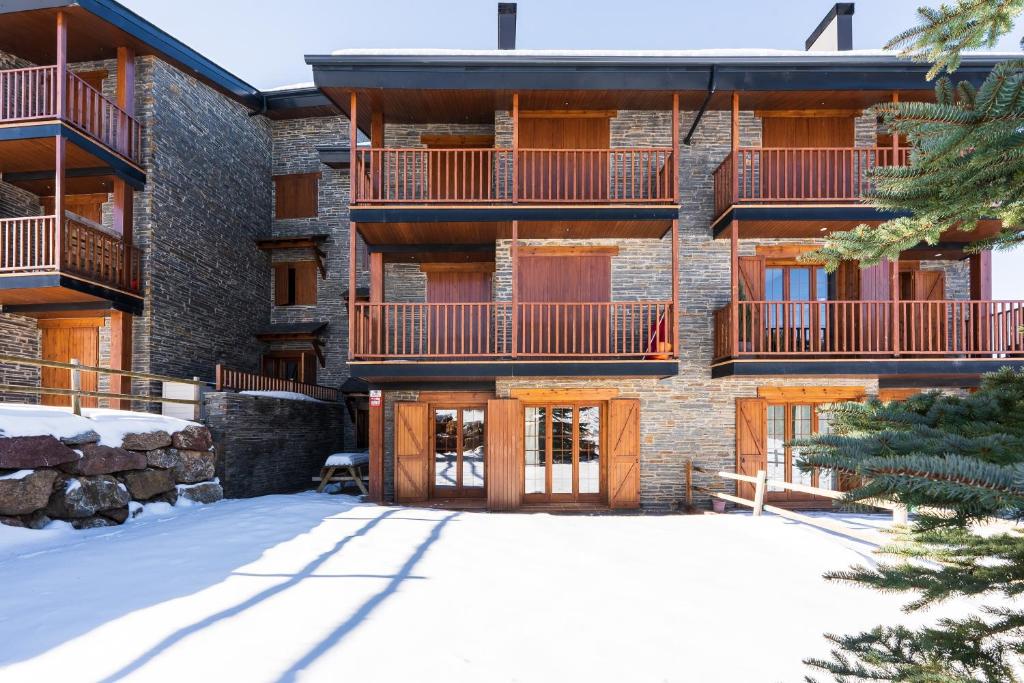 an apartment building with snow in front of it at Pie de pistas Fontcanaleta Lamolina in La Molina
