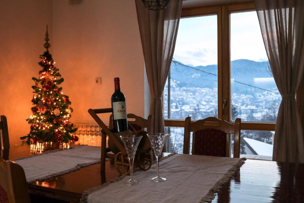 a table with a bottle of wine and a christmas tree at Apartment '84 in Pale