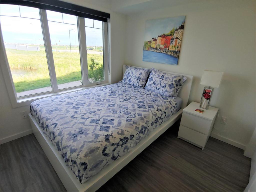 a bedroom with a bed and a window at Serene 2 bedroom condo with balcony and lakeview in Winnipeg
