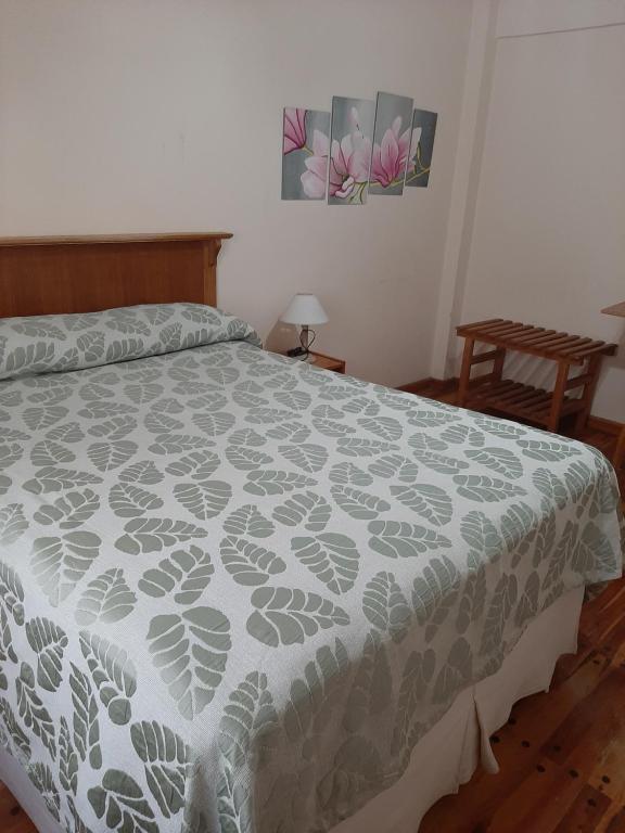 - une chambre dotée d'un lit avec un couvre-lit gris et blanc dans l'établissement LOWCOST MADRYN, à Puerto Madryn