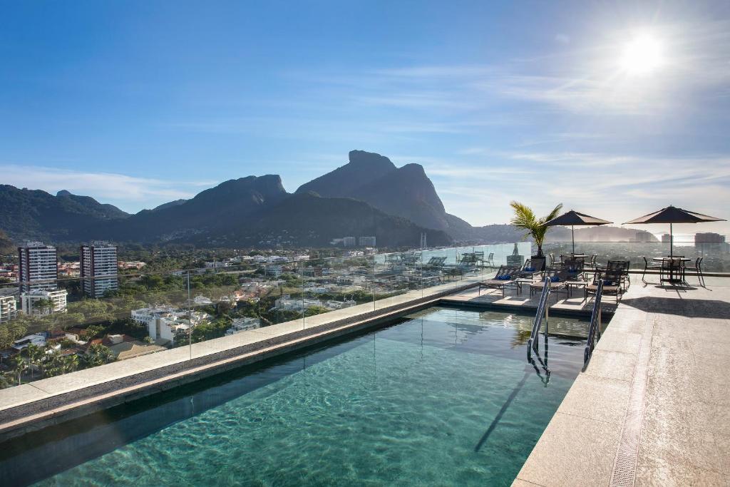 einen Pool mit Stühlen und Sonnenschirmen auf einem Gebäude in der Unterkunft Windsor Tower Hotel in Rio de Janeiro