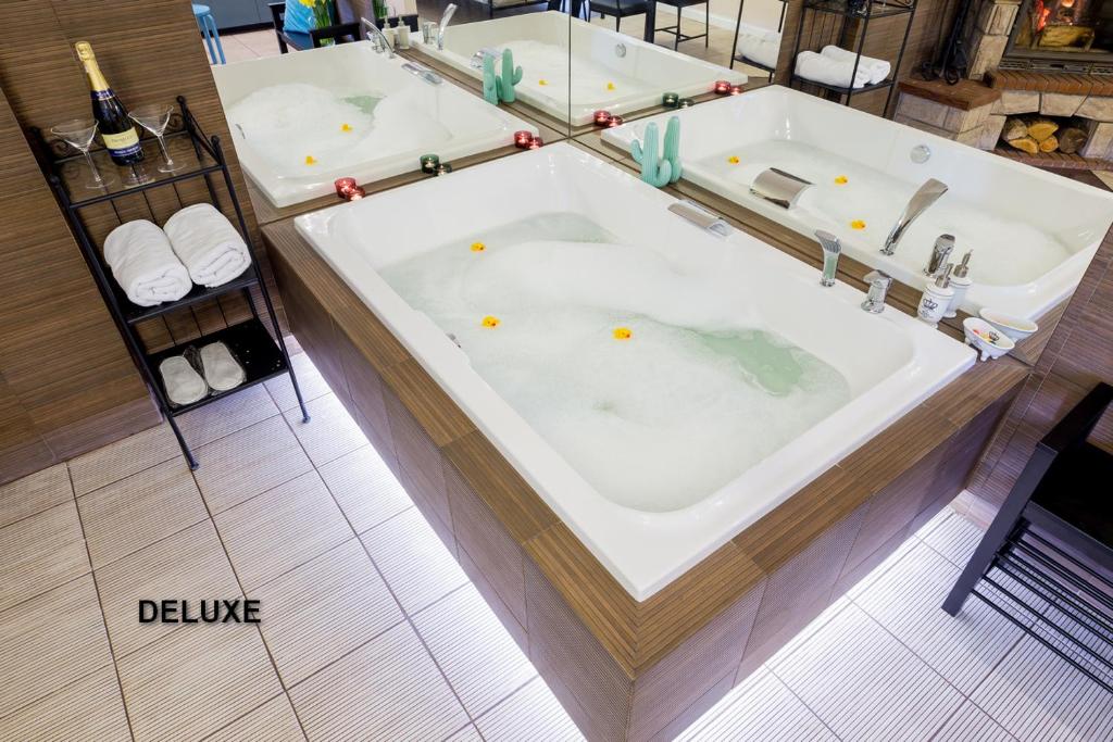 a large tub in a bathroom with two sinks at Apartamenty Centrum z wanną dwuosobową in Piotrków Trybunalski