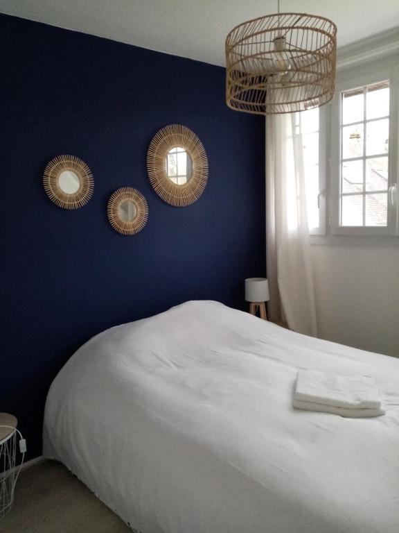 - une chambre avec des murs bleus et un lit blanc dans l'établissement Appartement 2 pièces proche du centre ville, à Bagnoles-de-l'Orne