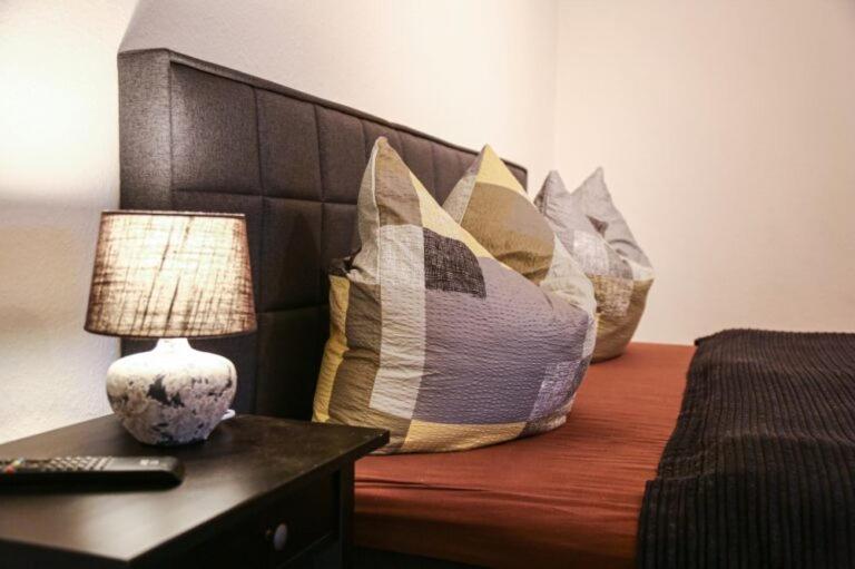 een bed met kussens en een lamp op een tafel bij Ferienhaus Spreewald Linde​ in Belten