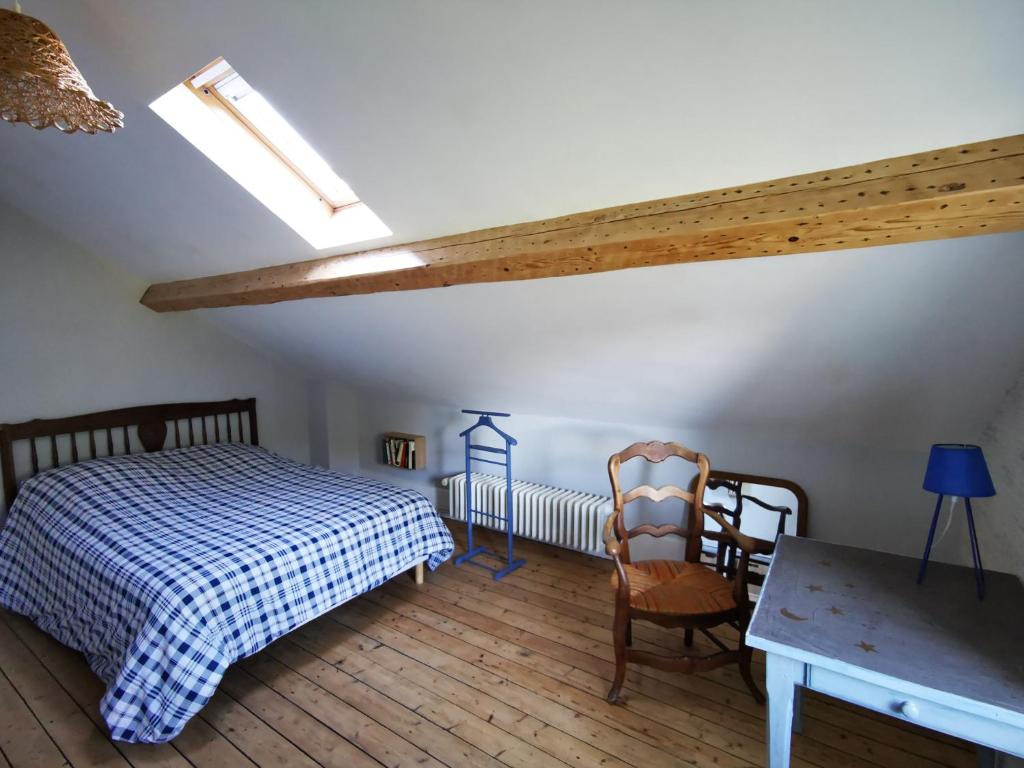 a bedroom with a bed and a table and chairs at Le Clos de la Borde, Chambre bleue in Arches
