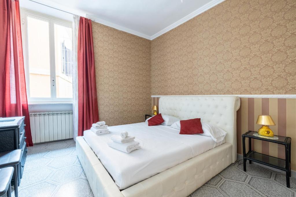 a bedroom with a large white bed with red curtains at [PIAZZA DI SPAGNA 5 STELLE] Parlamento Room in Rome