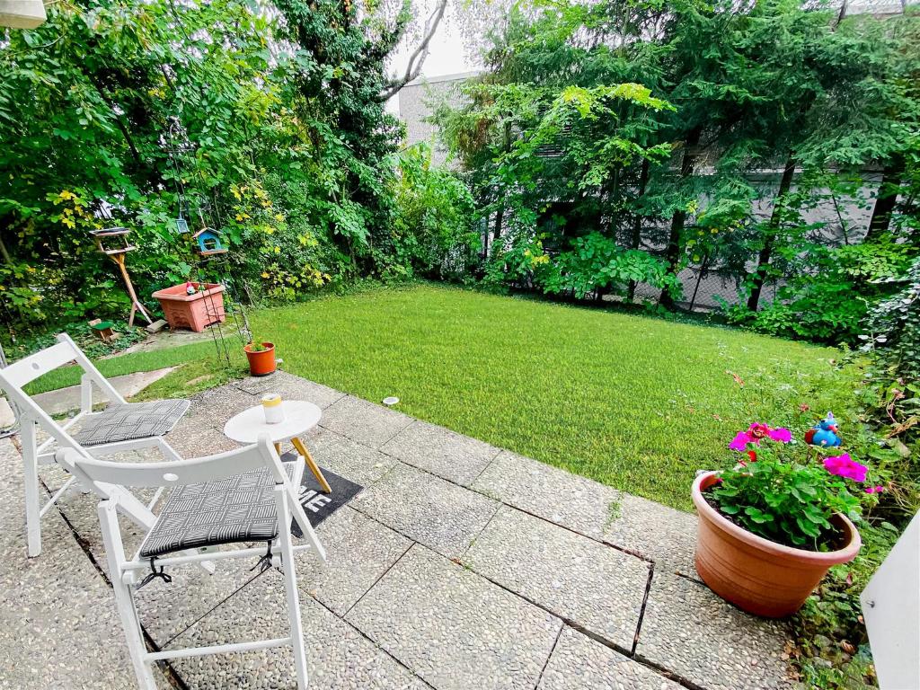 a patio with two chairs and a table and flowers at Little Black Forest Garden in Pforzheim