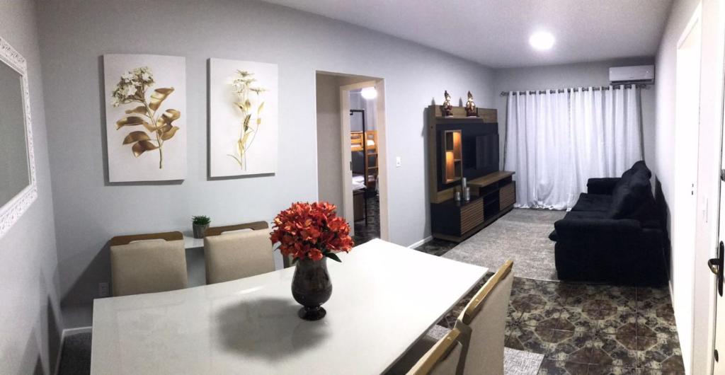 a living room with a vase of flowers on a table at Apartamento praia BC Central novo in Balneário Camboriú