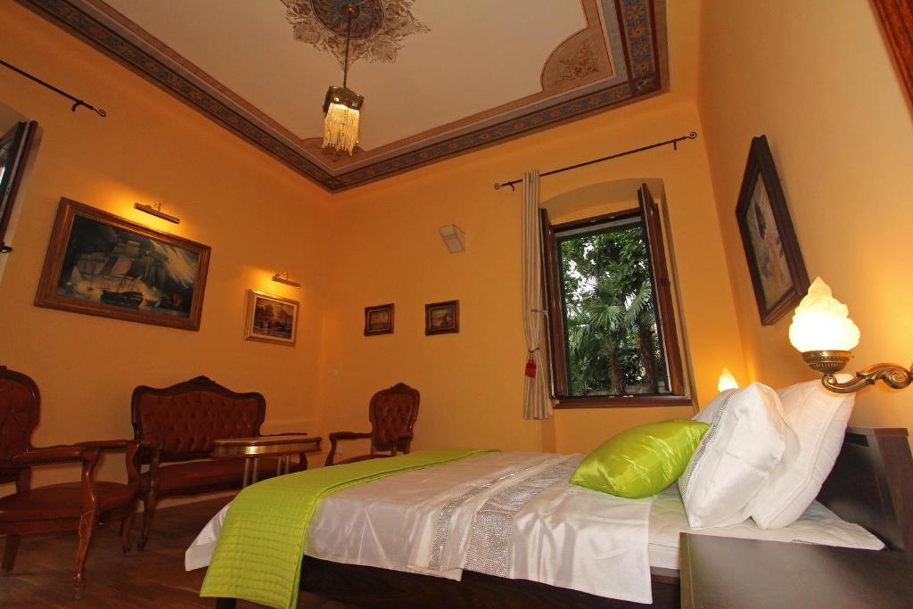een slaapkamer met een bed en een tafel en stoelen bij Villa Istria in Lovran