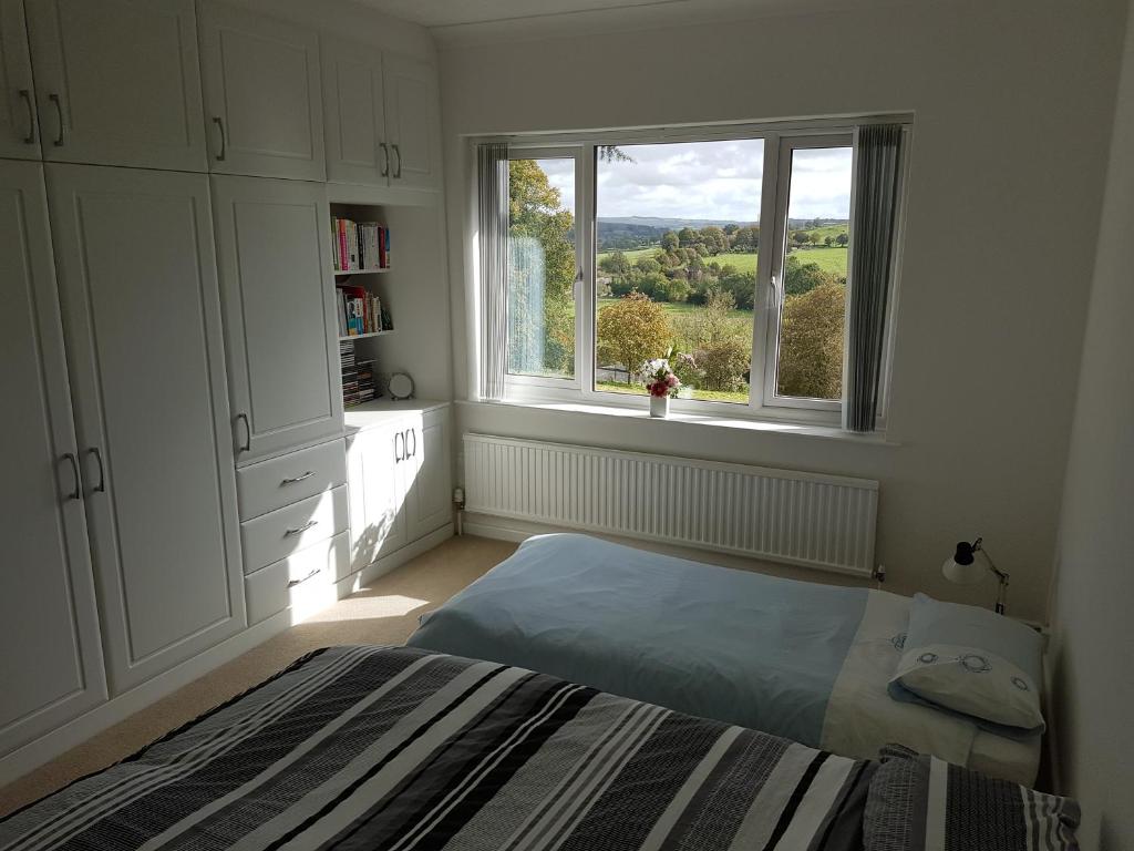 a bedroom with a bed and a large window at Luxury Endon House Share in Endon