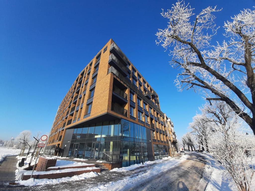 a building in the snow with snow covered trees at Chlebova z widokiem na Motławę - GYM i BAWIALNIA W CENIE in Gdańsk