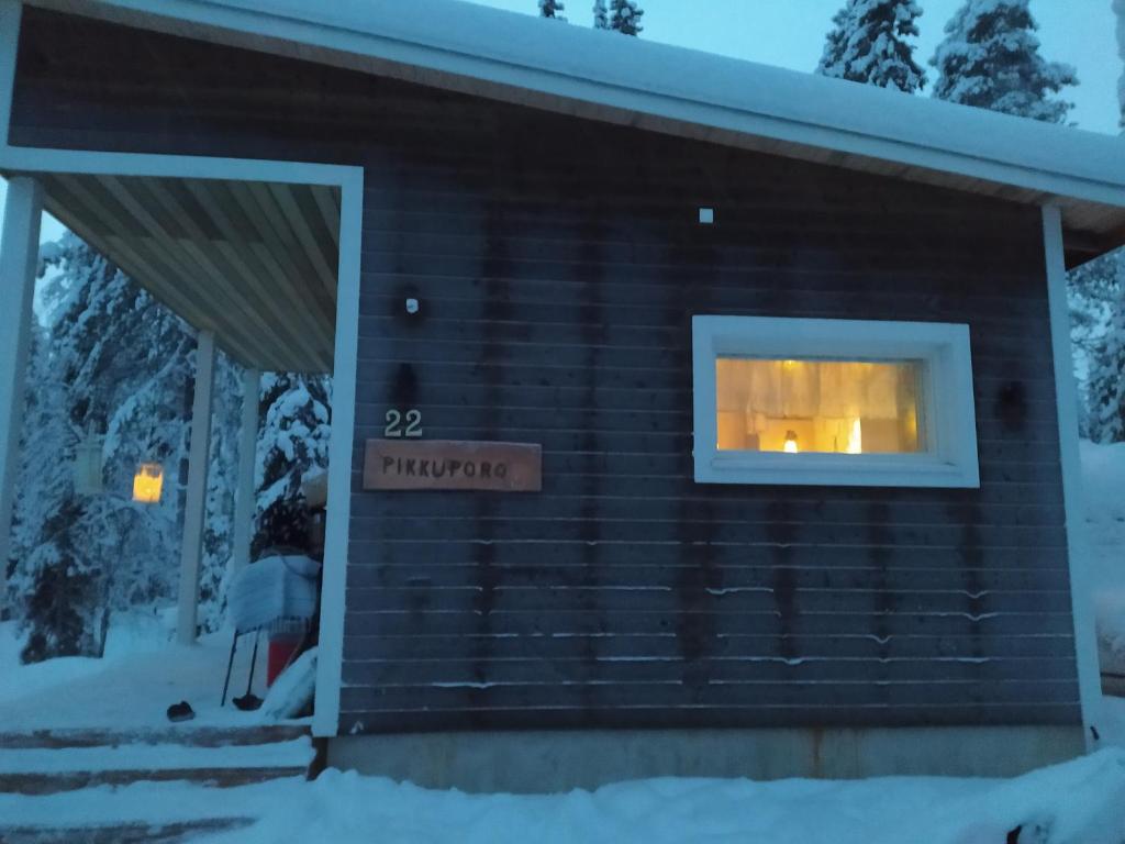 ein Blockhaus im Schnee mit Fenster in der Unterkunft Pikkuporo in Syöte