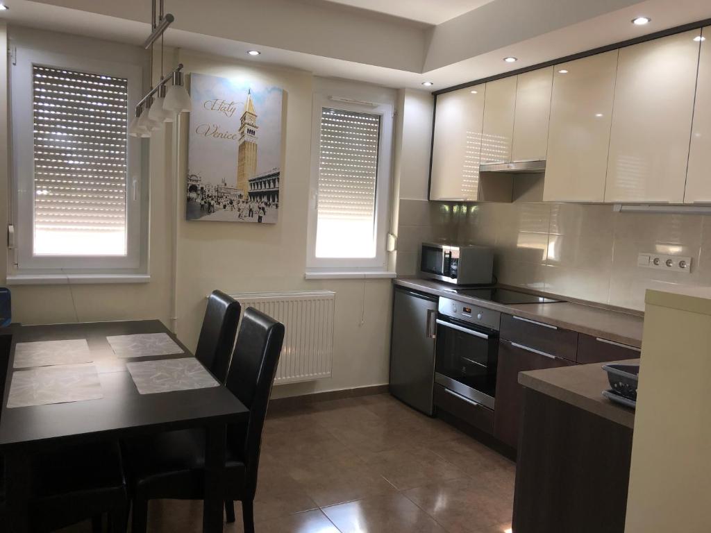 uma cozinha com uma mesa, um micro-ondas e um fogão em Csillagfény Apartment em Eger