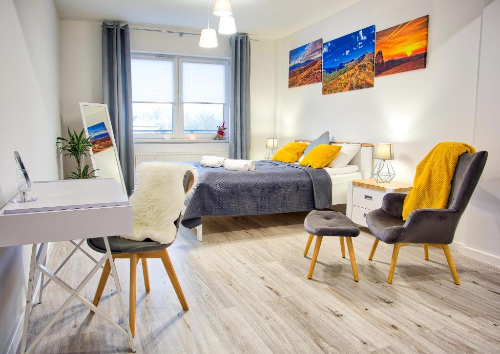 a bedroom with a bed and a desk and chairs at Apartament Rodzinny in Lesko