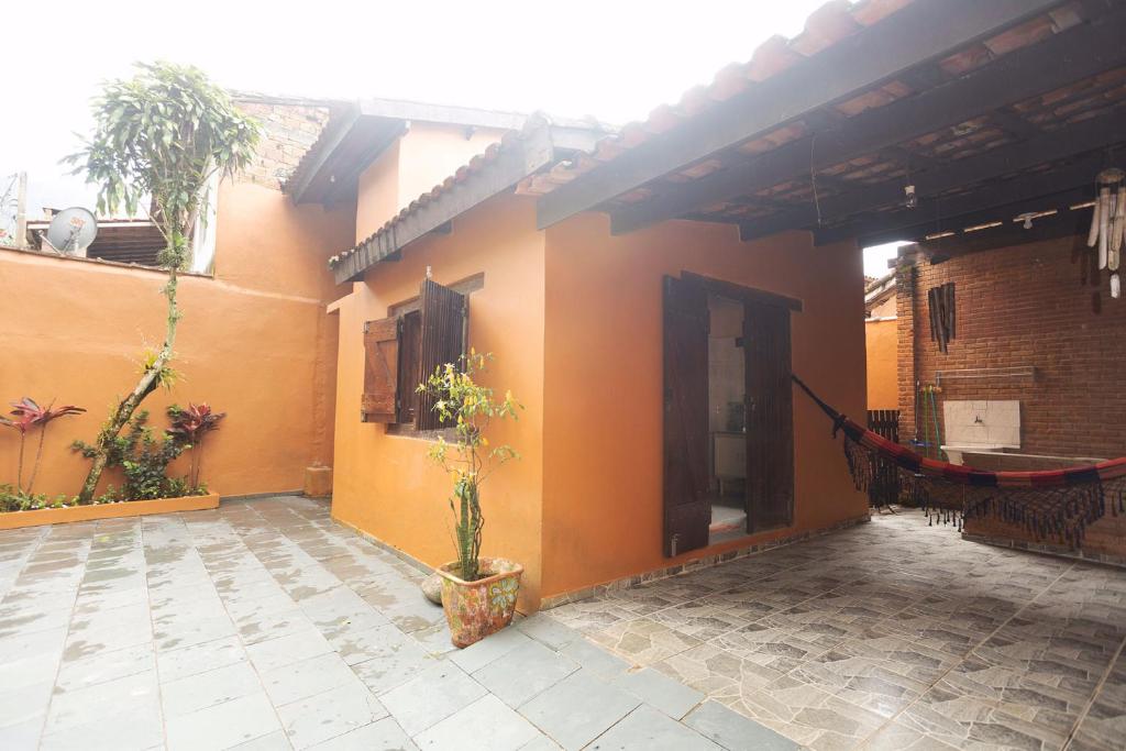 ein Haus mit einer Hängematte an der Seite in der Unterkunft Casa Maresias a 950m a pé da praia c churrasqueira in Maresias