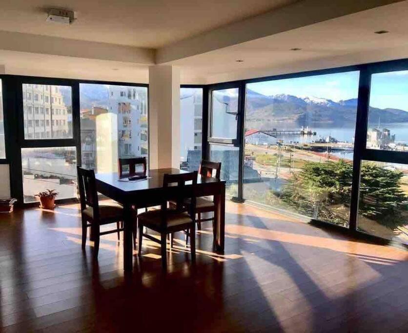 ein Esszimmer mit einem Tisch und Stühlen sowie einem großen Fenster in der Unterkunft Entire apartment in Patagonia rebate in physical dollar in Ushuaia