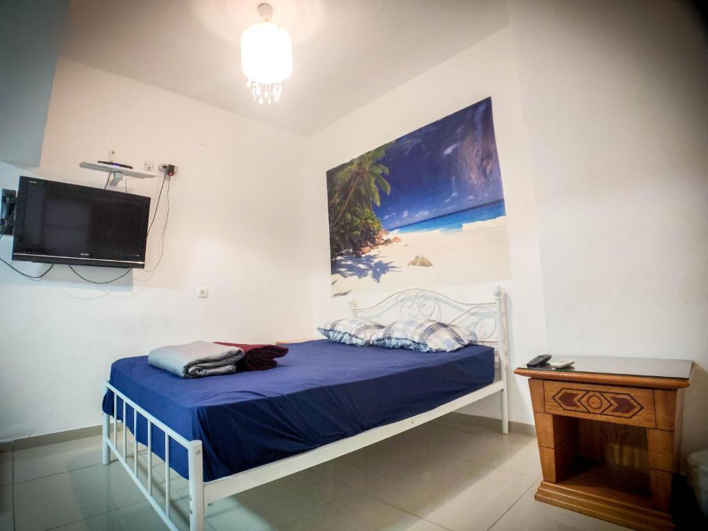 ein Schlafzimmer mit einem Bett und einem Fernseher an der Wand in der Unterkunft הבית הלבן של נתן in Eilat