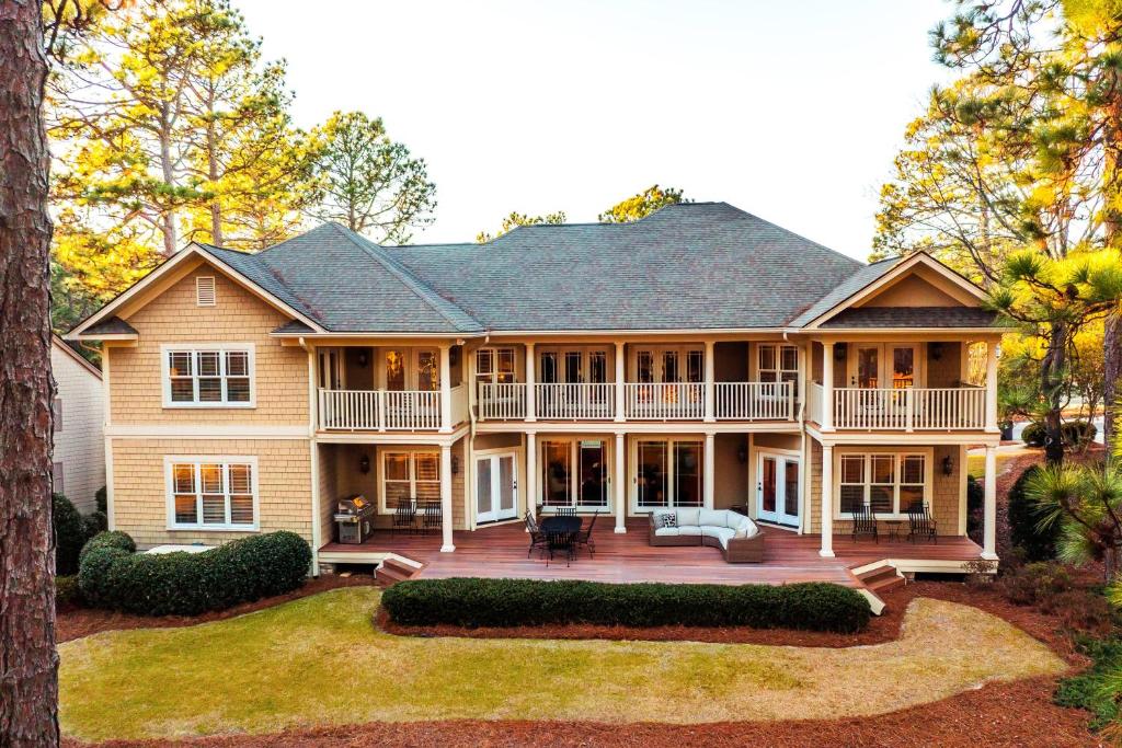 a large house with a porch and a deck at New - Spectacular️ Golf Views - Sleeps 20 - Pinehurst National #9 - Near DT Pinehurst! in Pinehurst