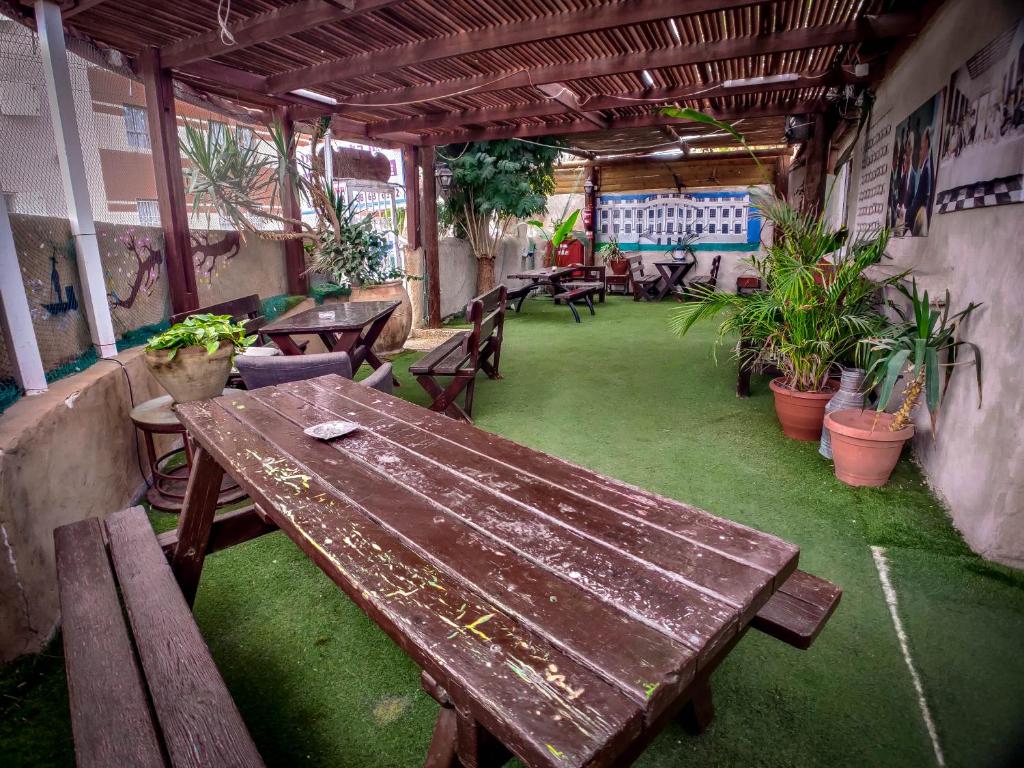 eine Außenterrasse mit einem Holztisch und Bänken in der Unterkunft הבית הלבן של נתן in Eilat