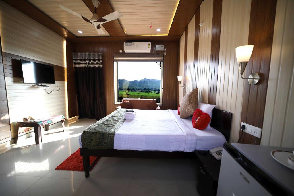 - une chambre avec un grand lit et une fenêtre dans l'établissement Bundeli Farm Resort & Banquet Orchha, à Orchha
