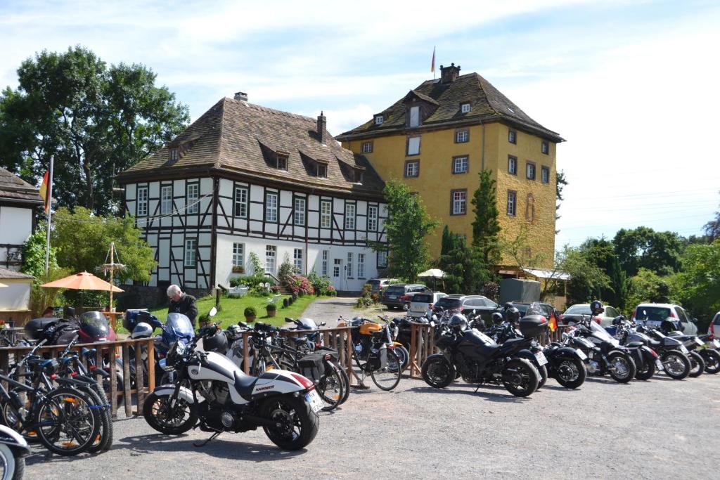 eine Gruppe von Motorrädern, die vor einem Gebäude geparkt sind in der Unterkunft Tonenburg in Höxter